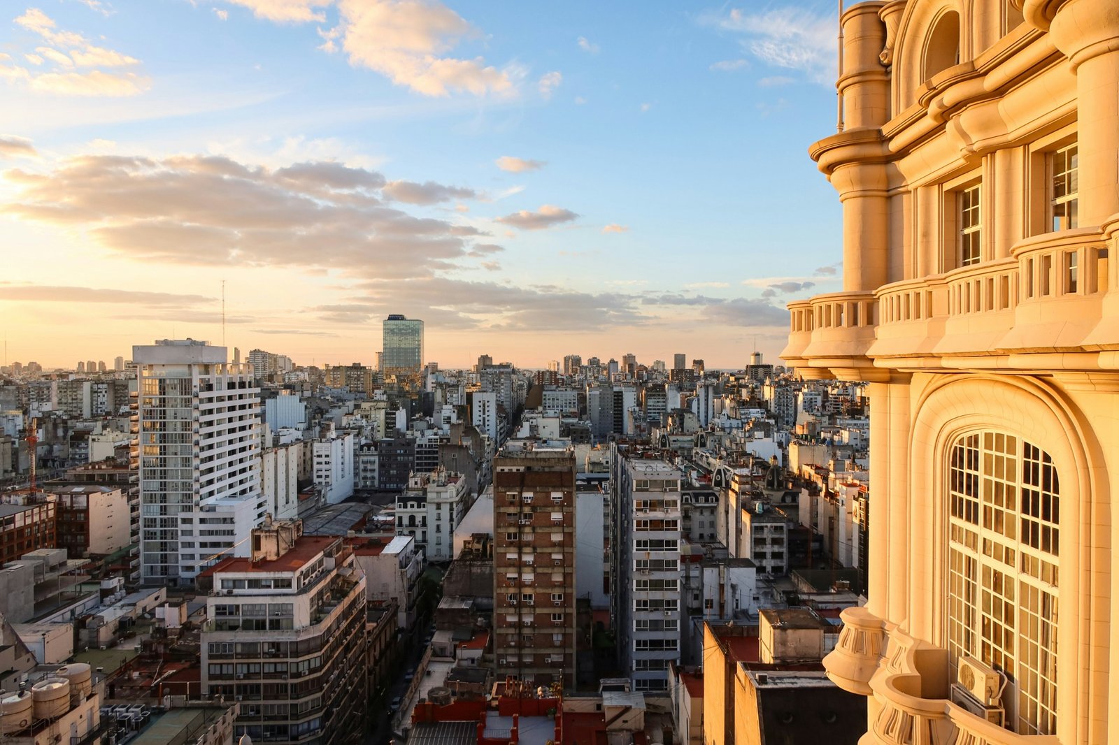 Fachada de un edificio con balcones y vista de Buenos Aires al atardecer